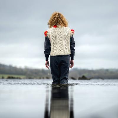 Woman stands in knee deep water with back to camera