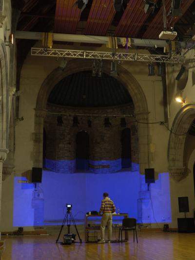 Person peforming in a dark church space.