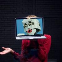 Person with laptop showing a robot's head in front of their face.